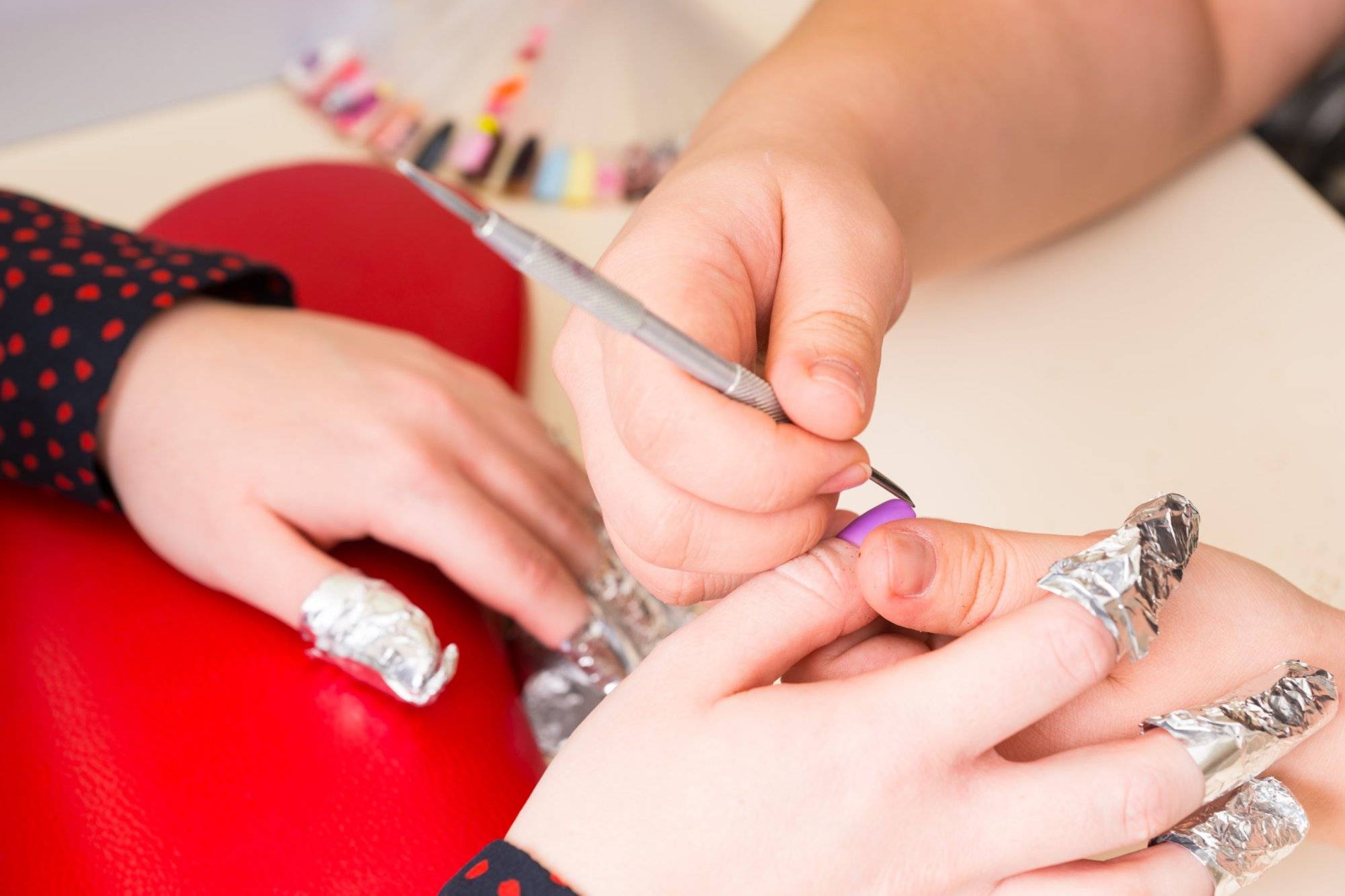 Manicurist Shaping Finger Nails with Tool in Spa