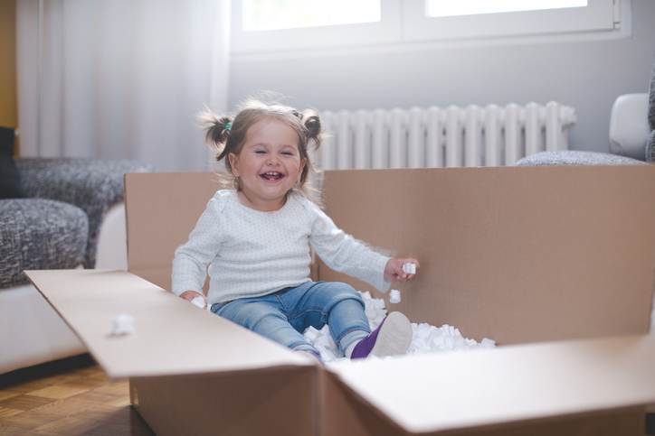 baby girl playing in box with styrofoam pellets