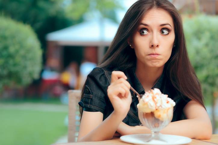 Girl Heisting to a Eat High Calorie Ice Cream Dessert