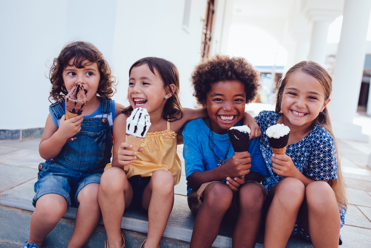 Group of cheerful multi-ethnic children eating ice-cream in summer